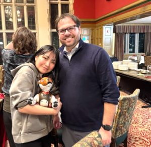 写真。懇親会にて、インディアナポリス動物園のChristopher Flynn Martin博士と自身のAIBOを抱いた筆者が写っている。