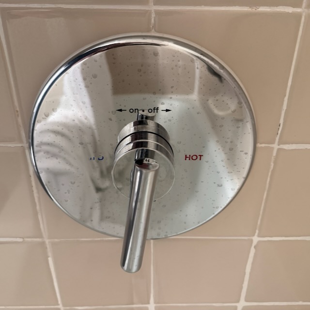 シャワーの操作の部の画像。on off と　cold hot　と左右対称位置に書かれているのだが、回転式のノブ自体はどちらが何を指しているのか不明。極めて使いにくい構造。