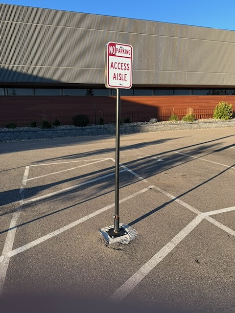 アクセス通路と書かれた標柱の画像。斜めに傾いている。よく見ると根本部分がバネ構造になっている。