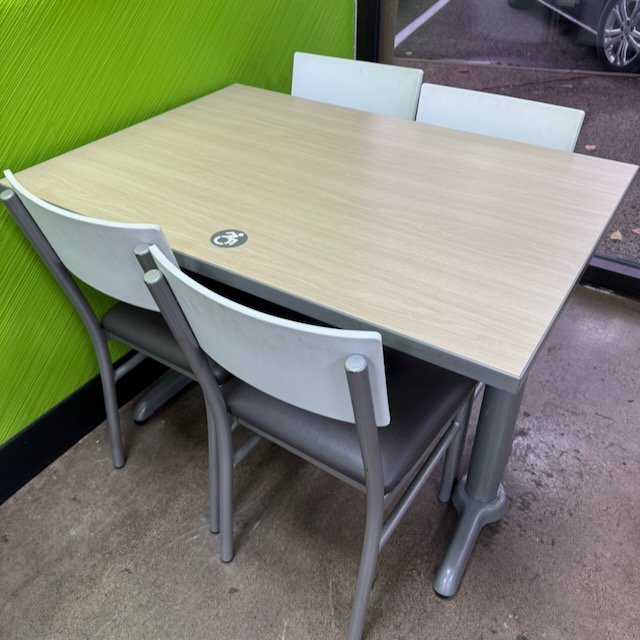 車椅子のシンボルマークが貼られた机。一般的に見られる抽象的な車椅子マークではなく、漕ぎ手が上に振り上げられ、前傾姿勢でダイナミック。