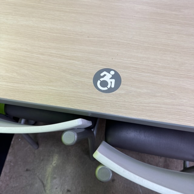 車椅子のシンボルマーク。一般的に見られる抽象的な車椅子マークではなく、漕ぎ手が上に振り上げられ、前傾姿勢でダイナミック。